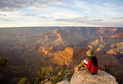 Woman Writing in Journal at Rim of Grand Canyon
